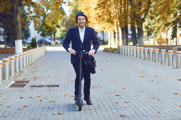 Young man in a helmet rides an electric scooter on a city street in summer © Studio Romantic