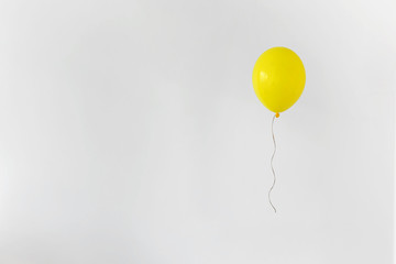 Yellow balloon on white background with copy space. Minimal party concept