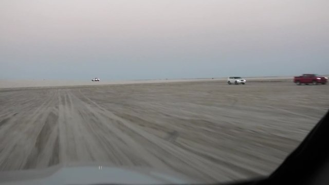 Off-road adventure with SUV cars in Arabian Desert. 4x4 vehicle bashing through sand dunes at Khor Al Udeid, the inland sea near Qatar and Saudi Arabian, Persian Gulf, Middle East.