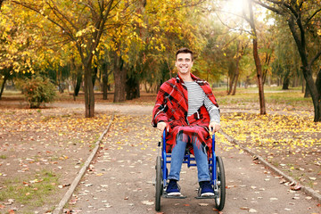Handicapped young man in autumn park