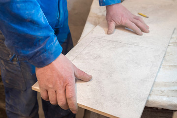 Builder bricklayer installs ceramic tiles. Apartment renovation.