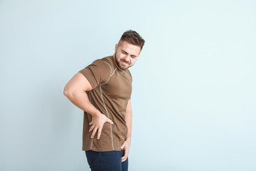 Young man with urologic disease on light background