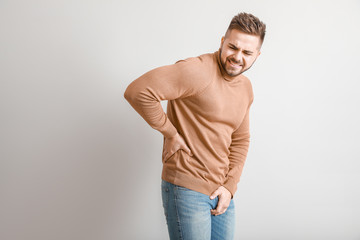 Young man with urologic disease on light background