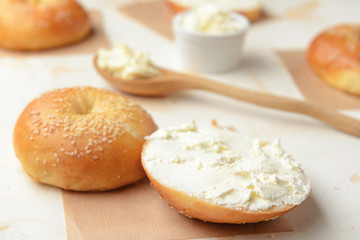 Fresh bun with tasty cream cheese on white background
