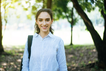 Beautiful young woman standing at public park in the morning,Happy and smiling,Relax time