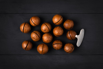 Macadamia nuts with a key on a dark wooden background in the center