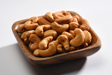 Cashews in a wooden bowl, on the white background