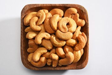 Cashews in a wooden bowl, on the white background