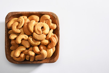 Cashews in a wooden bowl, on the white background