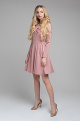Full length stock photo of gorgeous blonde woman with long wavy hair wearing romantic pink dress...