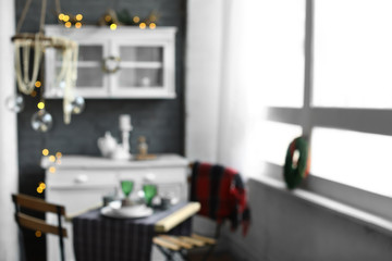 Interior of kitchen decorated for Christmas with served table, blurred view