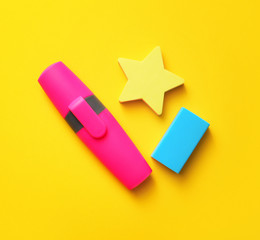 Erasers and marker on color background