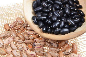 Dried borlotti black and brown beans in  in wooden bowl.