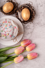 Easter cake with tulips and colored eggs top view flat lay
