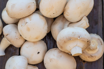 Fresh white Champignon mushrooms  on vintage wood table background