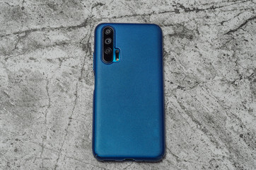 smartphone in a protective case in blue on an abstract light background
