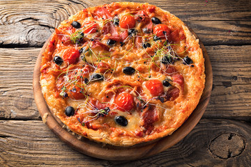 Delicious pizza served on wooden plate 