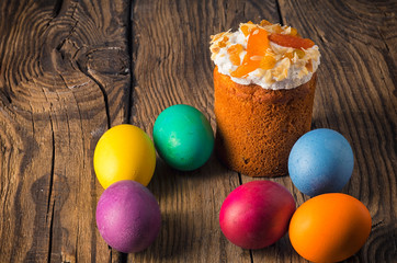 Easter cake and painted eggs on wooden table