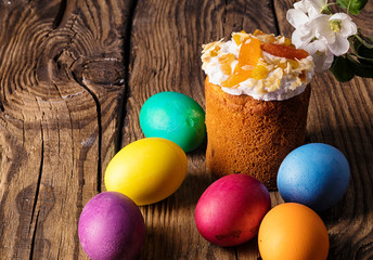 Easter cake and painted eggs on wooden table
