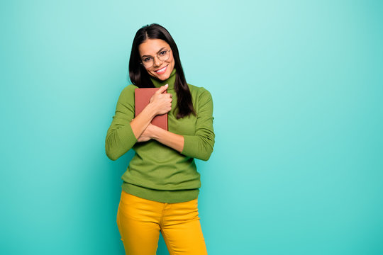 Portrait of her she nice-looking attractive cheerful cheery girl nerd holding in hands embracing favorite book isolated on bright vivid shine vibrant blue green turquoise color background