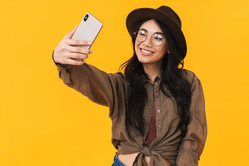 Naklejka premium Image of young brunette asian woman taking selfie photo on cellphone