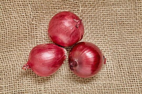 Red fresh ripe onions on Sackcloth. Close up.