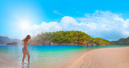 Fototapeta na wymiar Girl on tropical beach - Beautiful woman in bikini enjoy a swim in the crystal clear water - Oludeniz Beach And Blue Lagoon, Oludeniz beach is best beaches in Turkey - Fethiye, Turkey