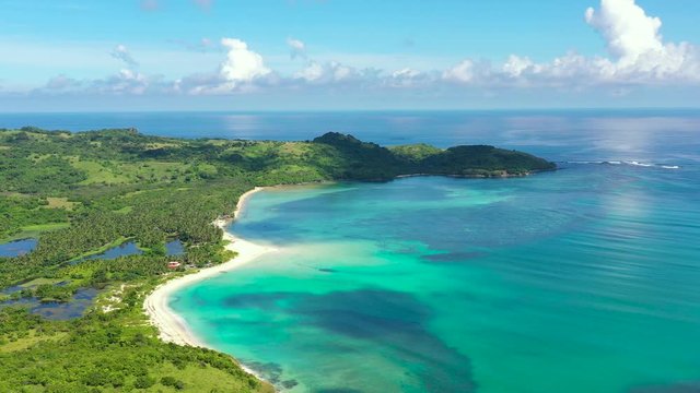 A tropical island with a turquoise lagoon and a sandbank. Caramoan Islands, Philippines.