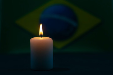 Obraz na płótnie Canvas Burning candle on the background of the flag of Brazil. Memorial Day