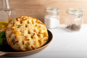 Freshly baked Italian bread Focaccia on a stone plate.