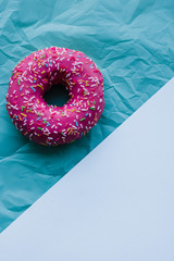 bright pink donut on a turquoise white background