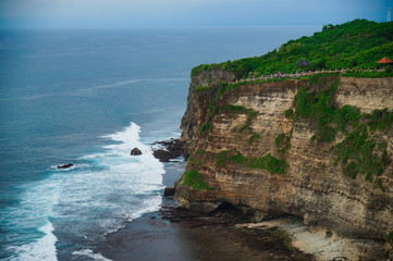 A beautiful ocean in Bali. The Pacific Ocean with large waves and tides that break on the rocks. The Indian Ocean is blue. Aqua Mente and Phantom Blue. Golden sunset on the ocean on the island of Bali