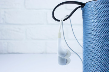 Wireless portable speaker and white headphones for connecting to other device on a white background. концепция музыки, спорта, движения.