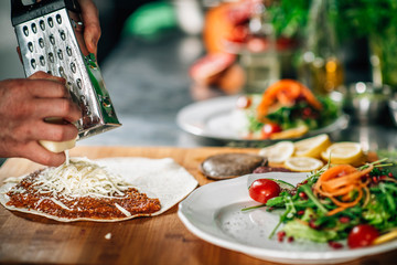 Preparing Vegetarian Burrito - Chef Grating Cheese with a Grater