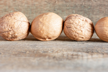Close-up healthy chopped and unshelled walnuts on a wooden old table. Vegetarian food