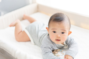 ベビーベッドで遊ぶ赤ちゃん