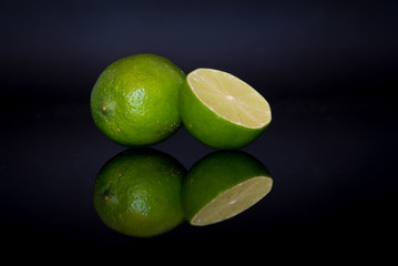 Fresh lime reflection against black background
