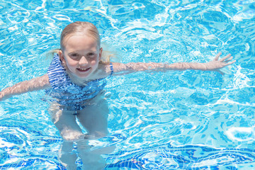 Pretty little girl in swimming pool, summer vacations.