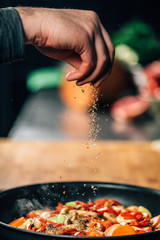 Seasoning - Chef Sprinkling Oregano over Vegetables