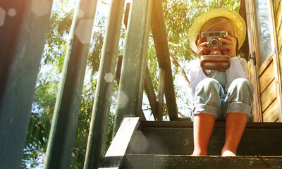 Little blond girl enjoying summer vacation time at the tree house. Gardening