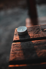 Candle burning at sunset on the table outside.