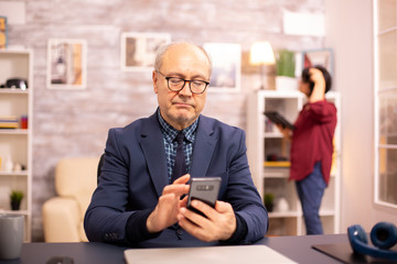 Old man using new technology in cozy house