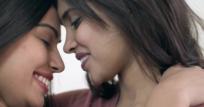 Hot, young and sexy Indian lesbian lovers embrace each other with passion as they come face to face almost about to kiss each other and looking with lustfully romantic engagement with fire of desire