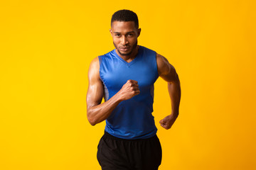 Serious afro guy running at camera at studio