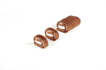 Sliced chocolate biscuit roll cake isolated on white background.