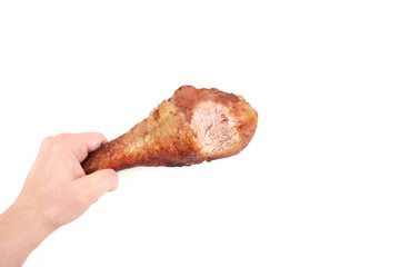 hand holding roasted turkey leg with bite taken , isolated on white background.