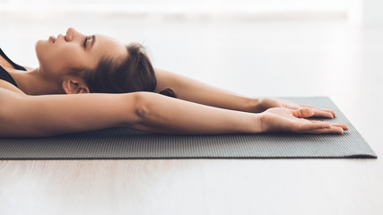 Woman stretching lying on the floor in modern studio