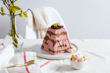Easter cherry chocolate curd cake with nest and eggs on festive table. Easter greeting card. Orthodox Easter. Copy space