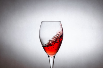 glass of red wine on a white background in motion. Freezing liquids in motion