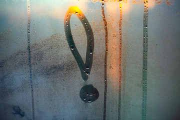 Exclamation mark written with a finger on the fogged glass, sun glare